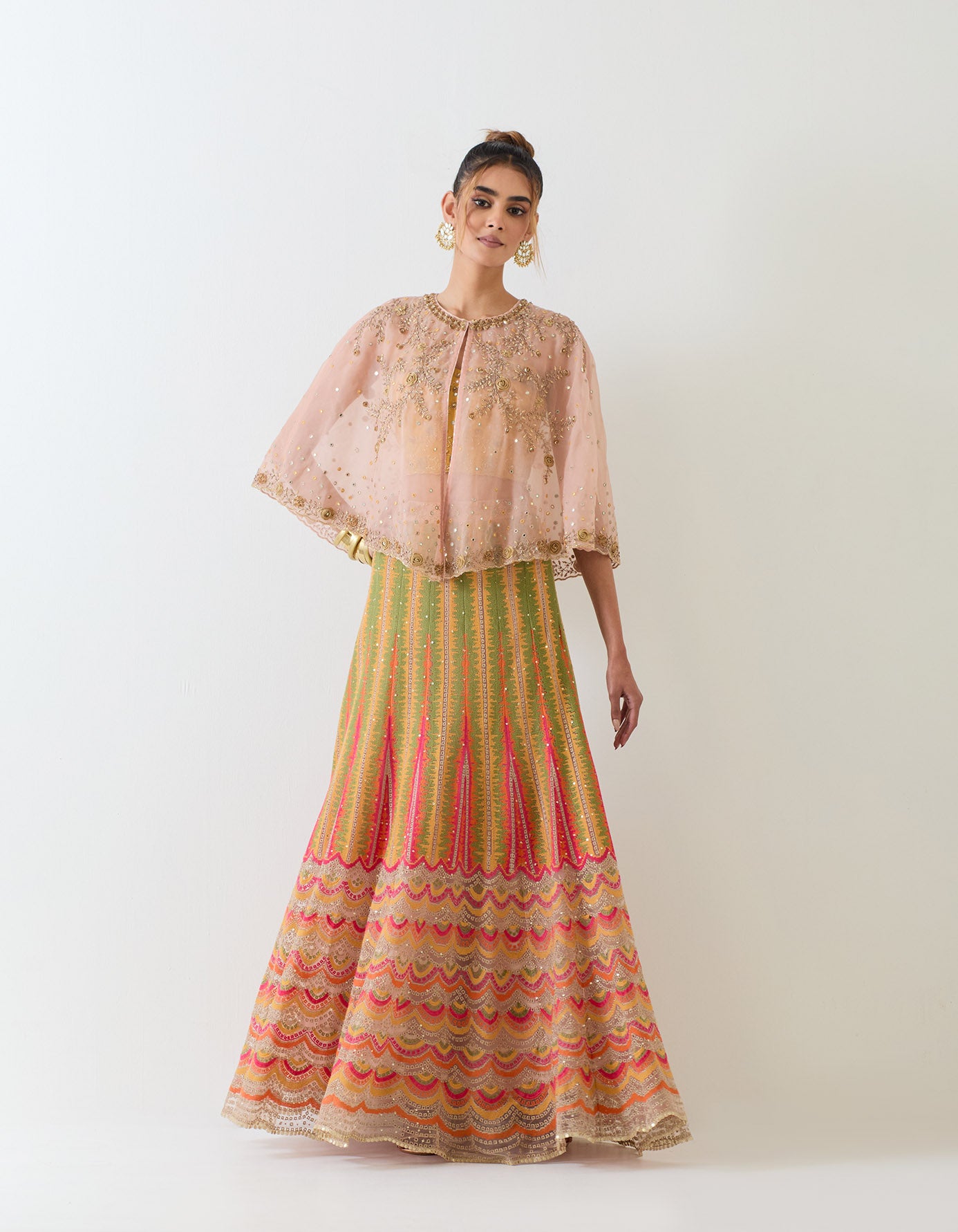 Pale pink organza circular cape paired with cross stitch embroidered skirt and hand embellished bustier