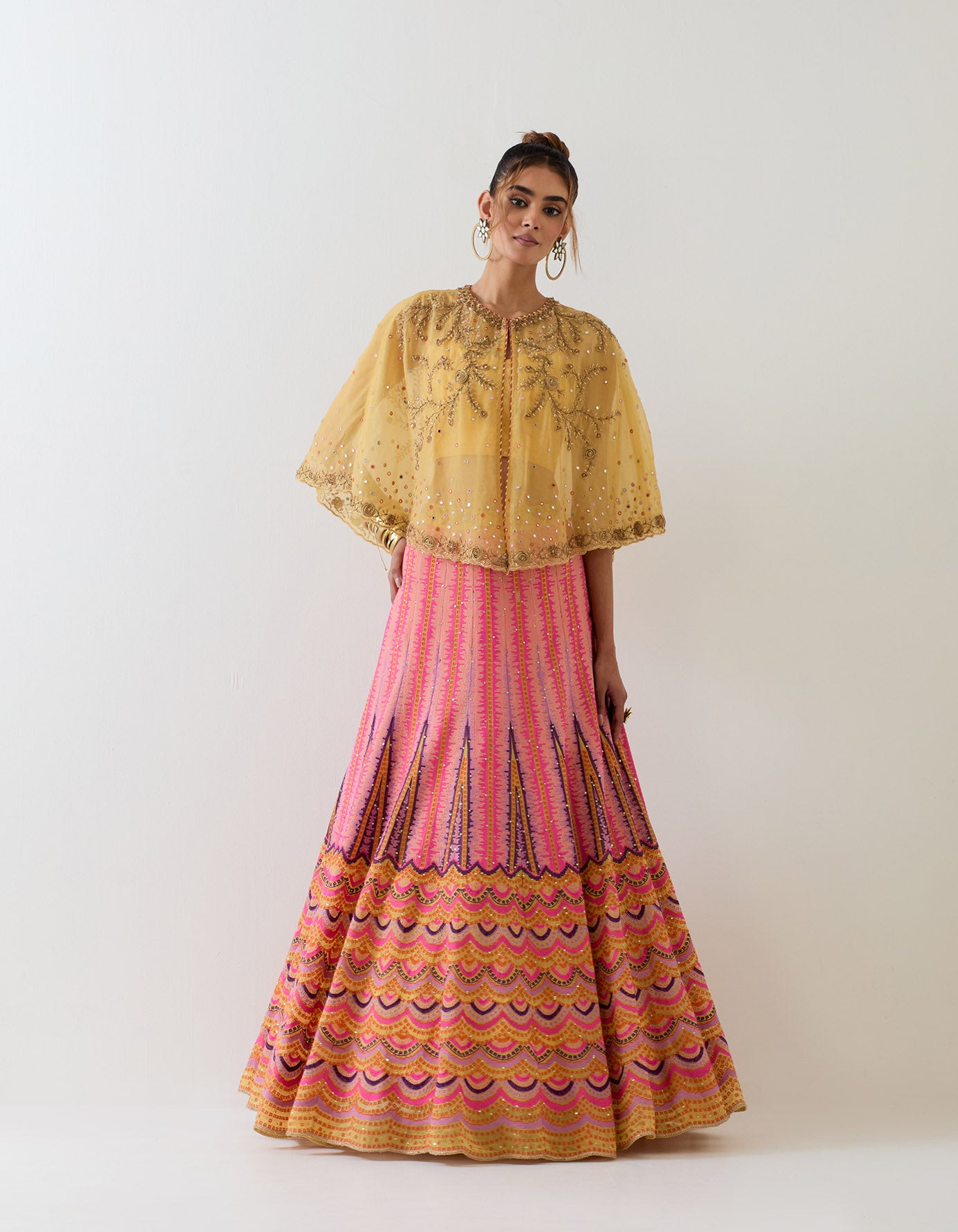 Mustard yellow organza circular cape paired with cross stitch embroidered skirt and foil printed stretch bustier