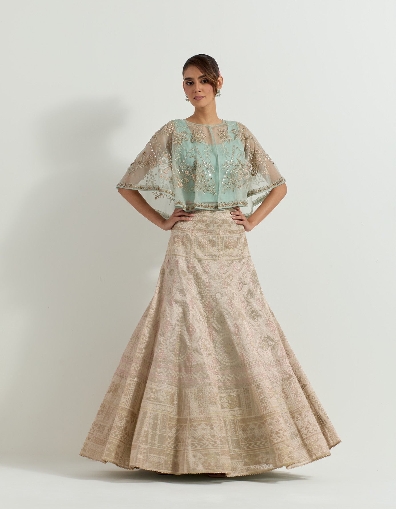 Hand embellished circular organza cape paired with sage tissue skirt in bandhini motifs