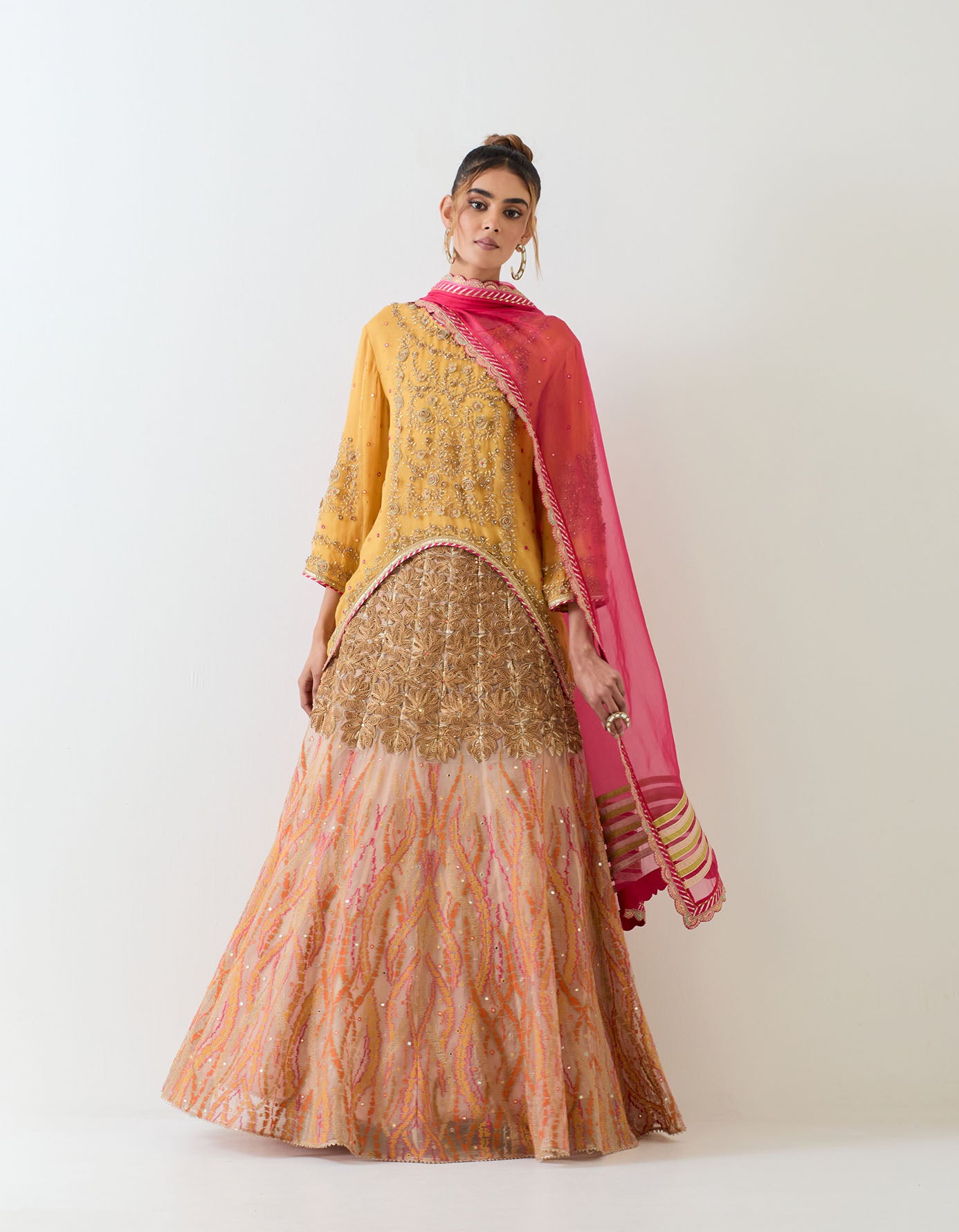 Organza hand embellished high low tunic paired with gota, mirror work and cross stitch embroidered skirt and fuchsia organza dupatta