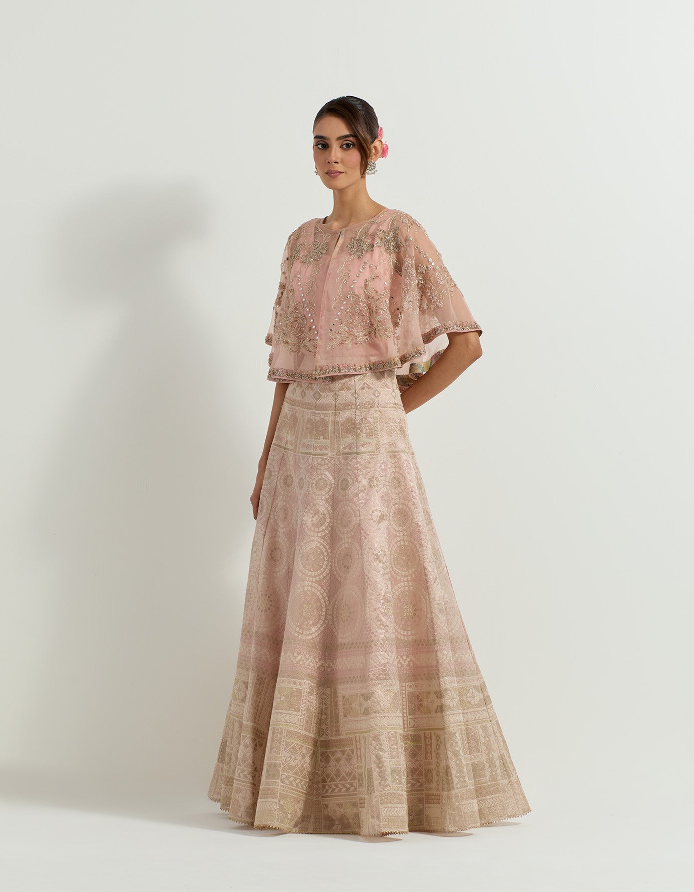 Hand embellished circular organza cape paired with blush pink tissue skirt in bandhini motifs