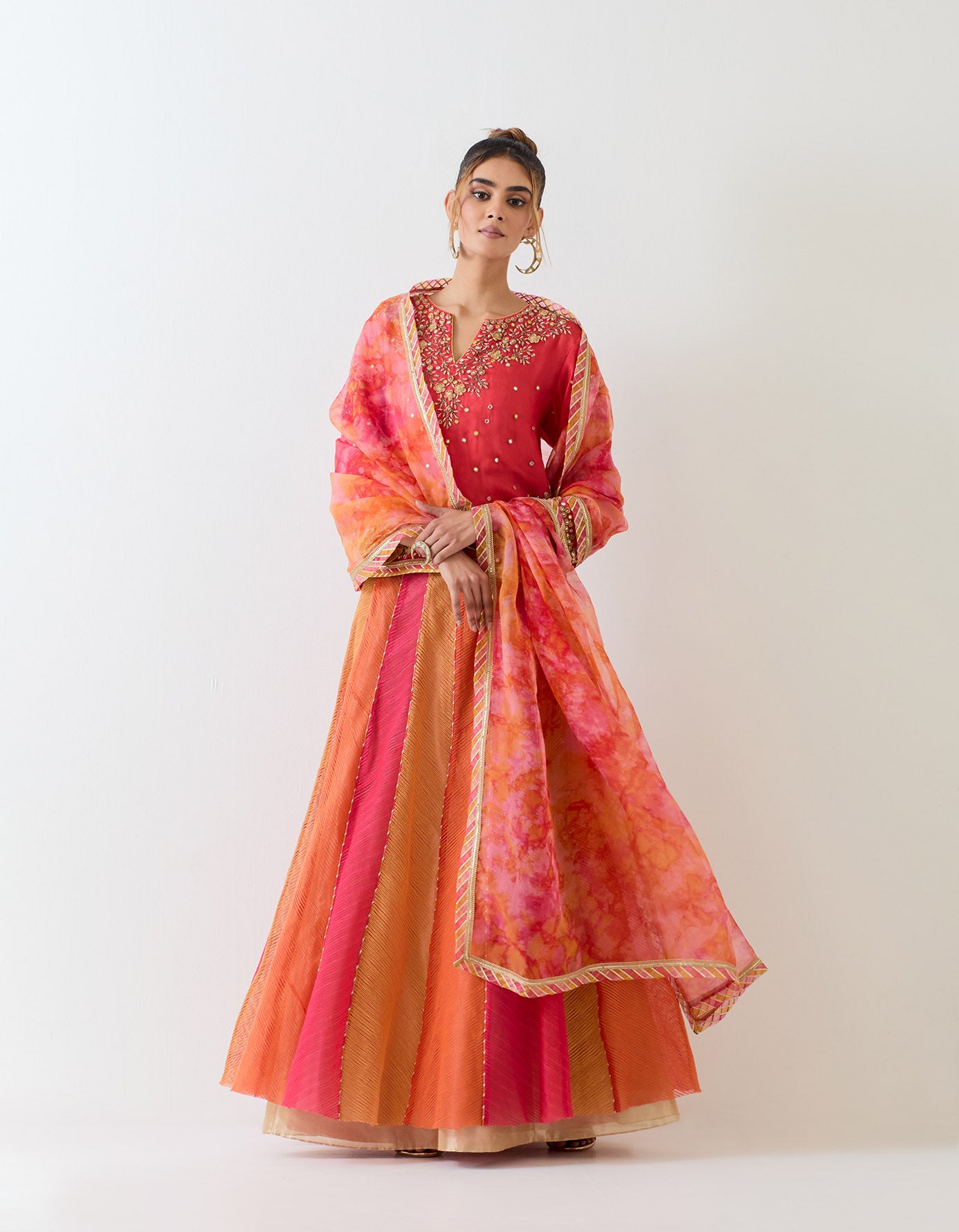 Hand embellished organza kurti paired with textured panelled skirt with hand embroidered waist and organza dupatta