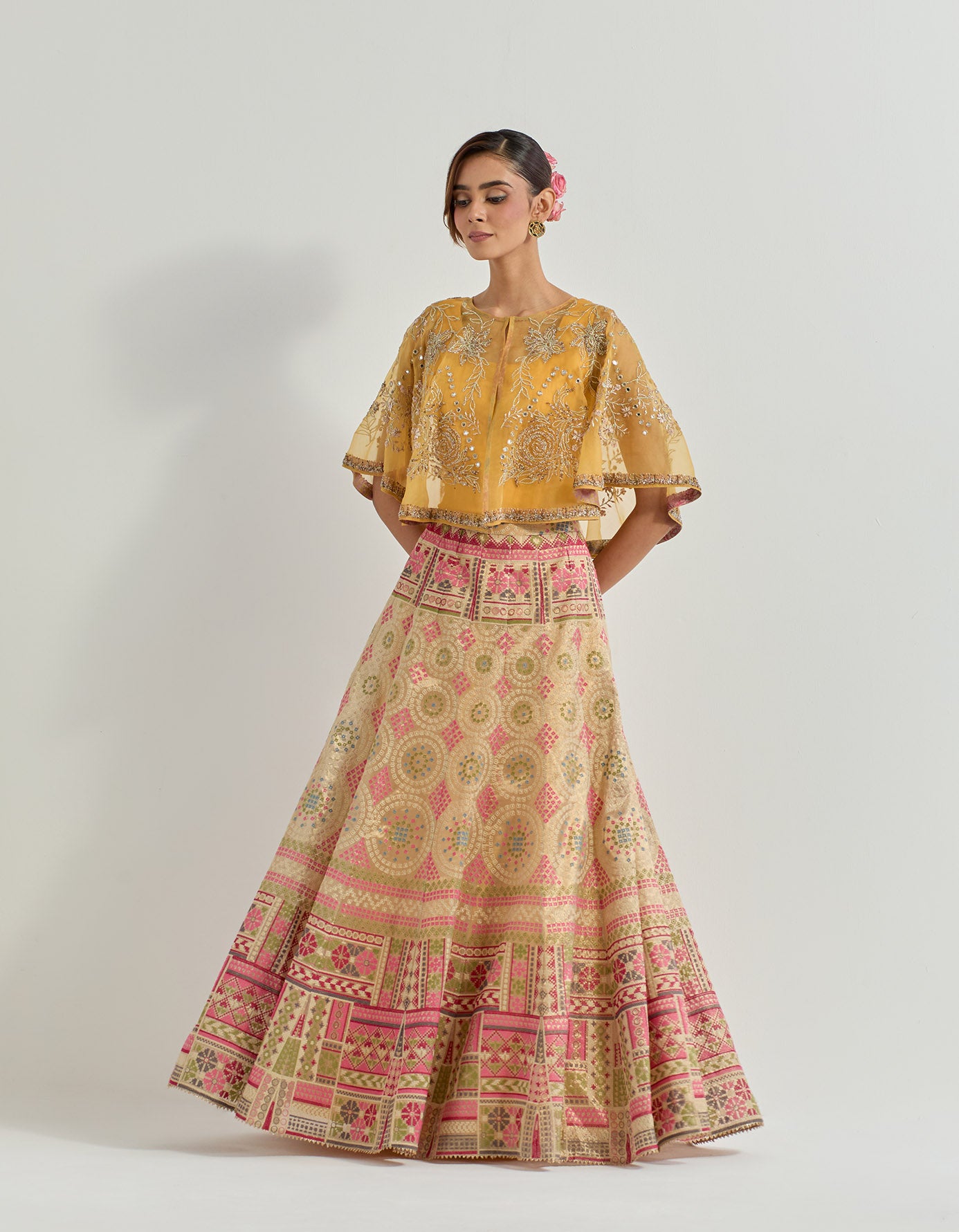 Hand embellished circular organza cape paired with gold and yellow tissue skirt in bandhini motifs
