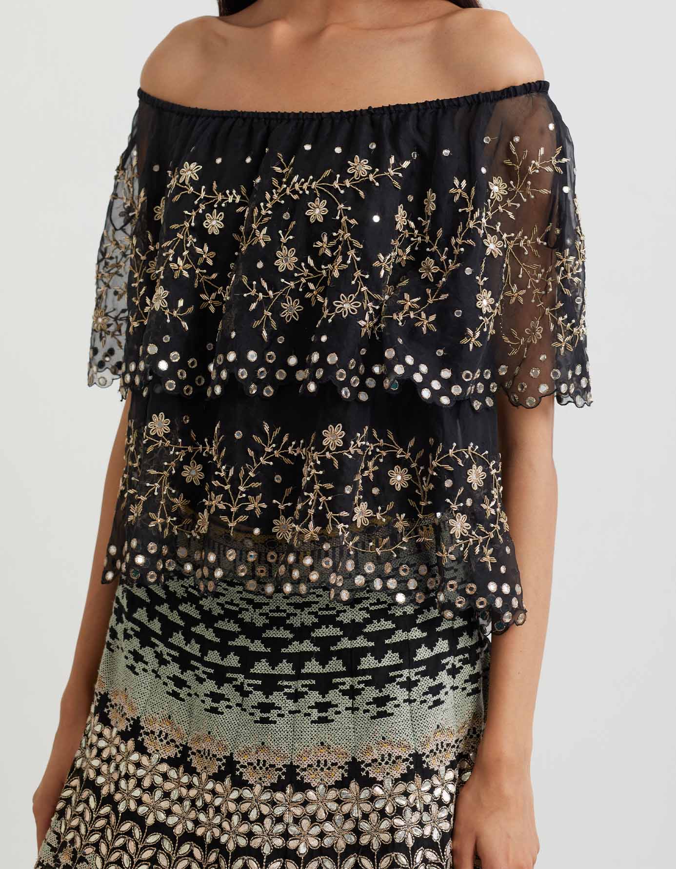 Black cross stitch embroidered skirt in landscape motif paired with organza off shoulder double layered cape in zardozi embroidery