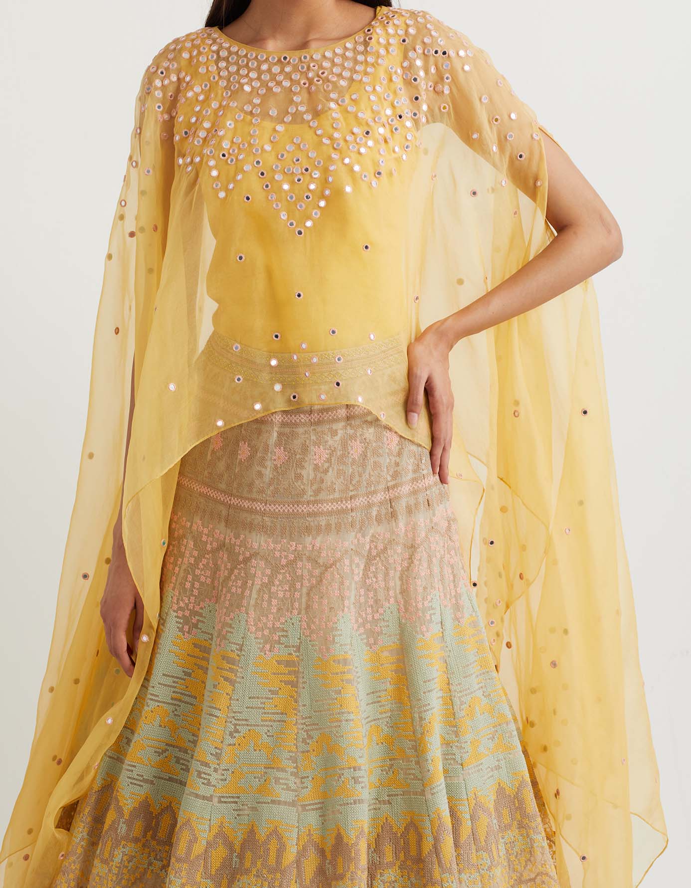 Lemon cross stitch embroidered skirt in landscape motif paired with organza dupatta cape in mirror embroidery