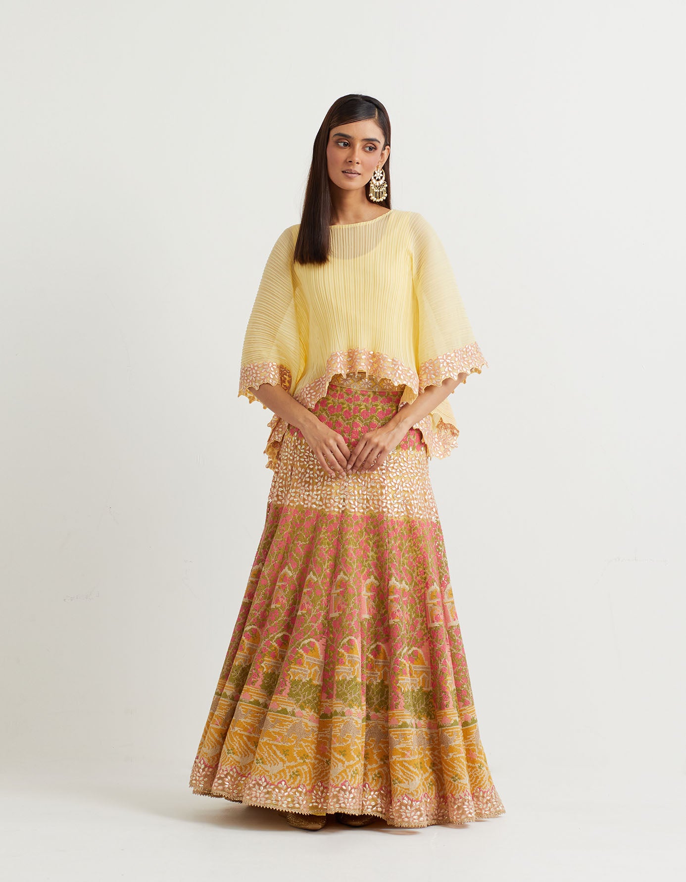 Yellow cross stitch embroidered skirt in landscape motif paired with crinkle georgette poncho top in gota embroidery