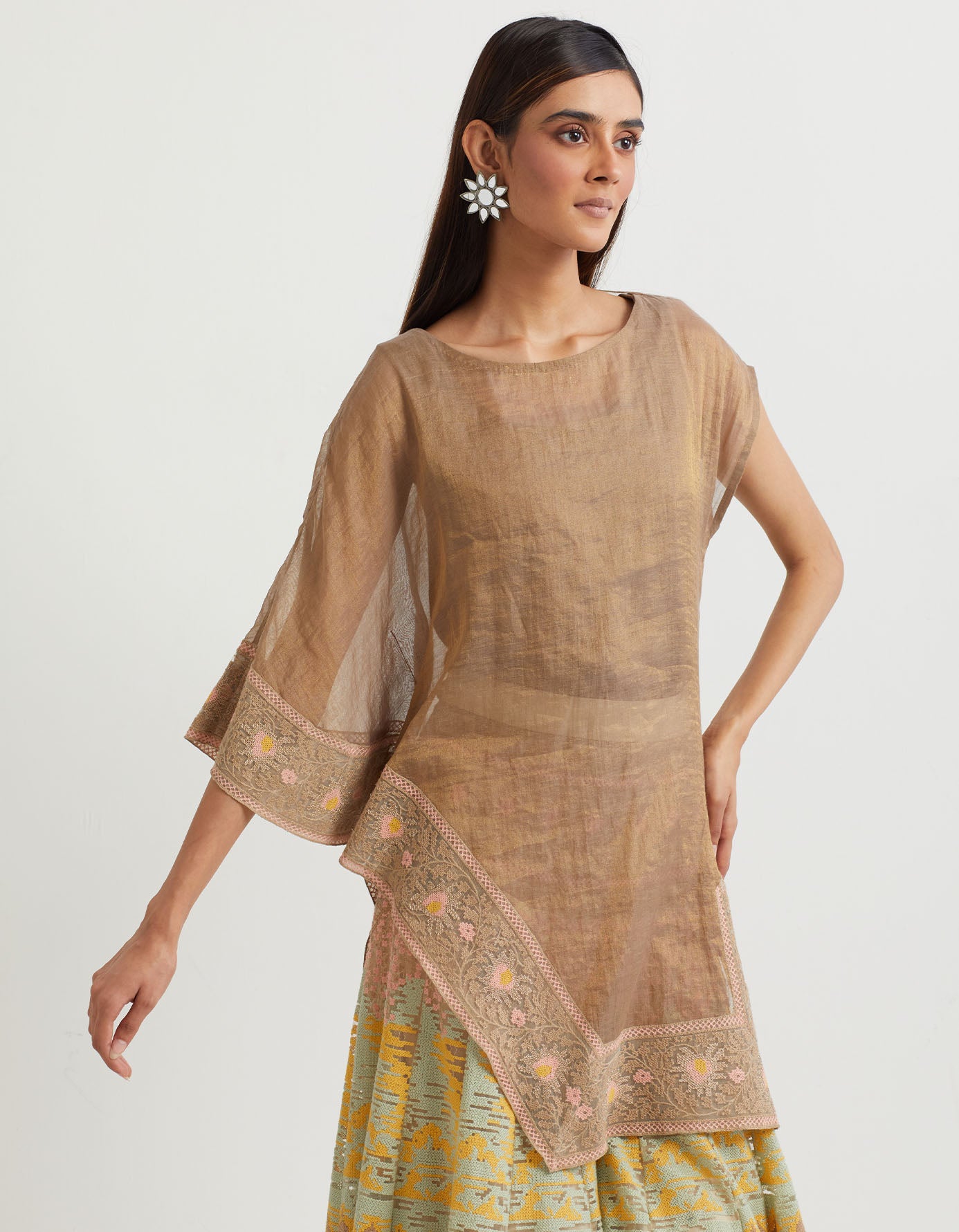 French beige cross stitch embroidered sharara in landscape motif paired with tissue chanderi asymetric cape in matching cross stitch border