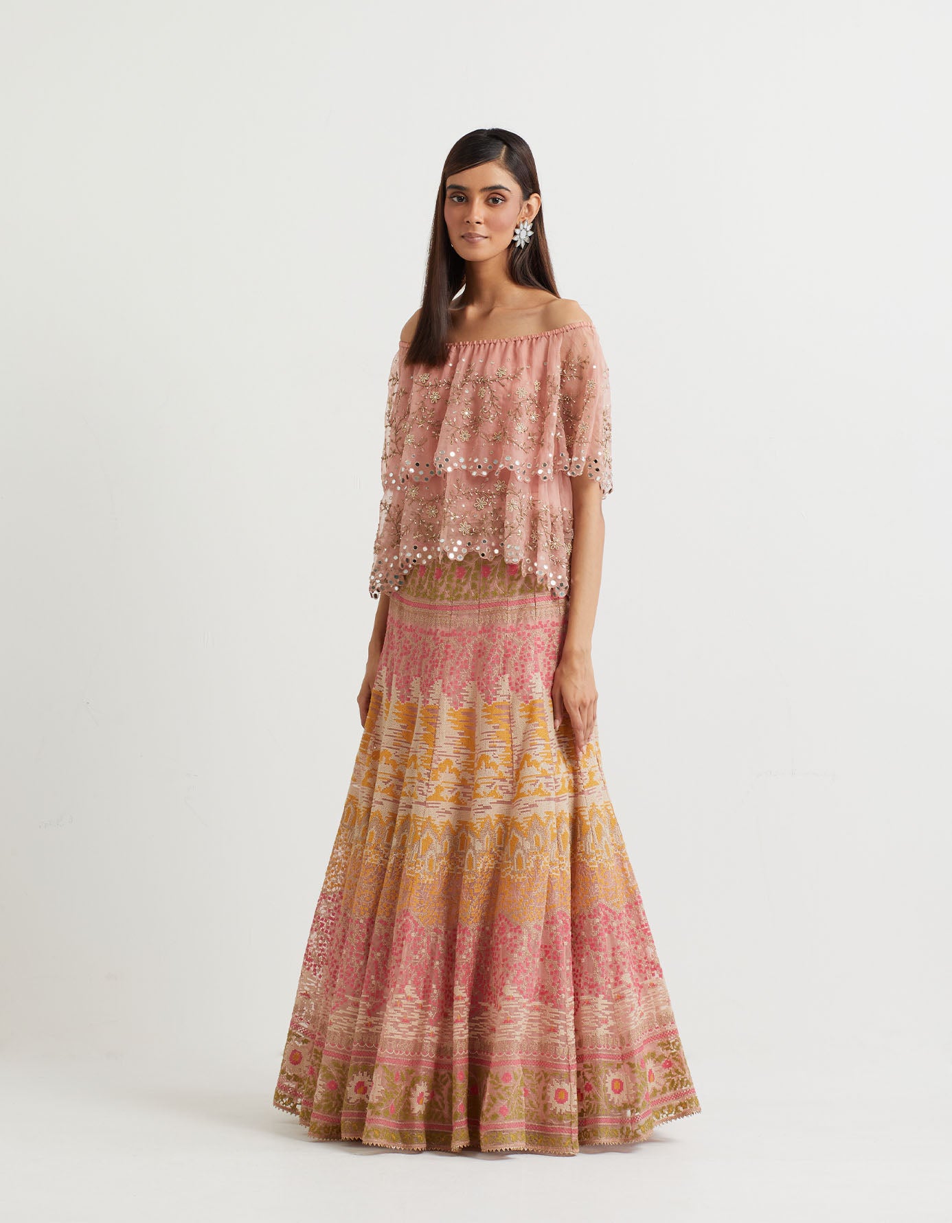 Pink cross stitch embroidered skirt in landscape motif paired with organza off shoulder double layered cape in zardozi embroidery