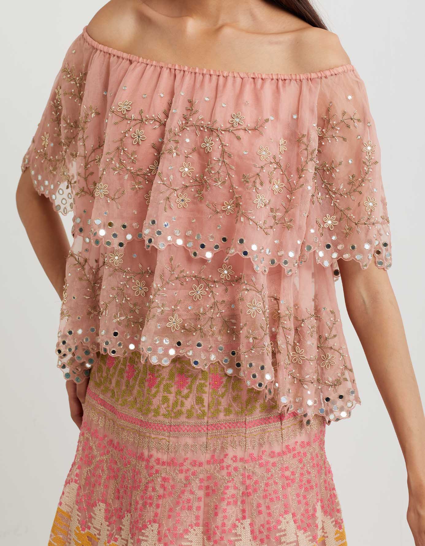 Pink cross stitch embroidered skirt in landscape motif paired with organza off shoulder double layered cape in zardozi embroidery