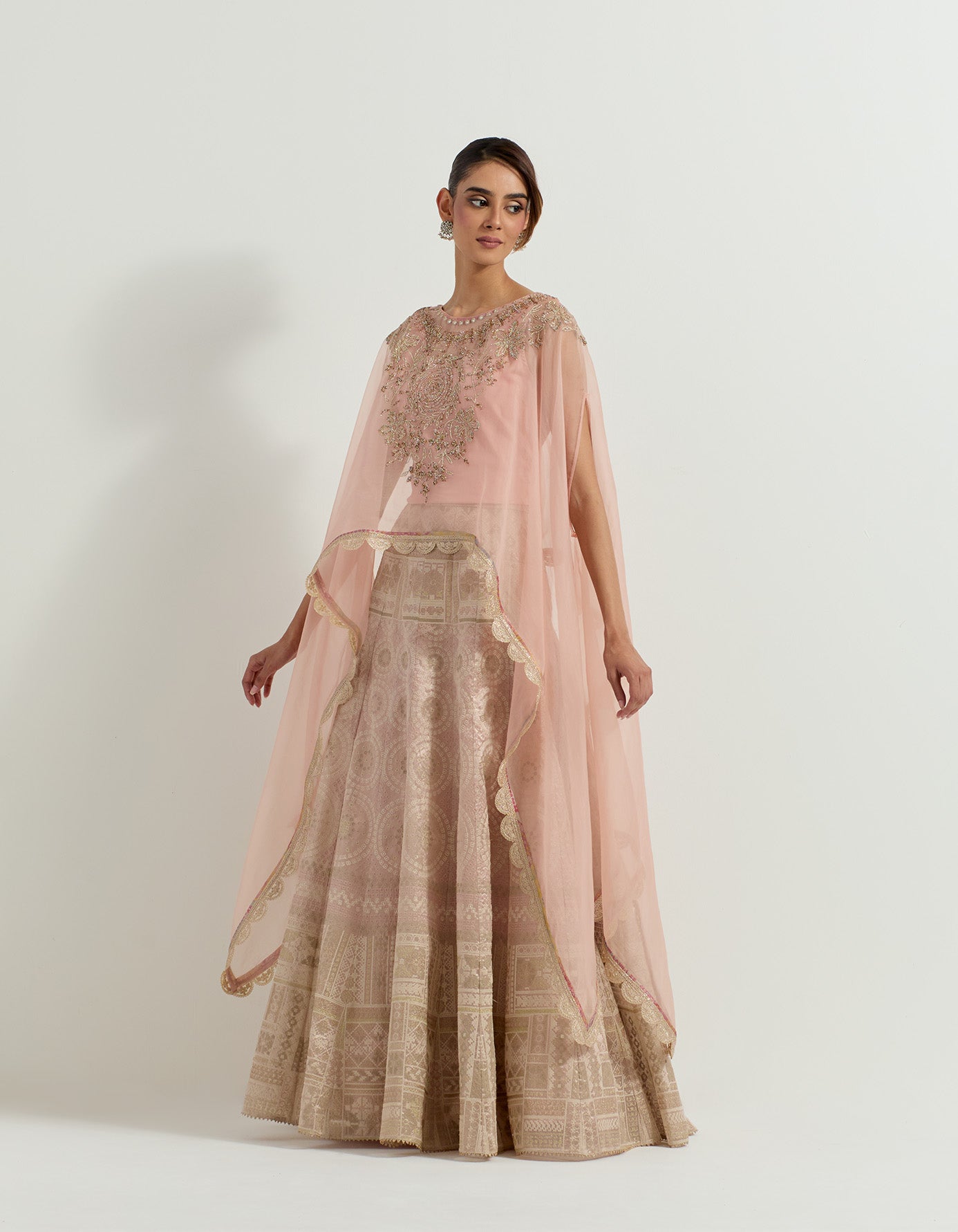 Hand embellished dupatta cape paired with blush pink tissue  skirt in bandhini motifs