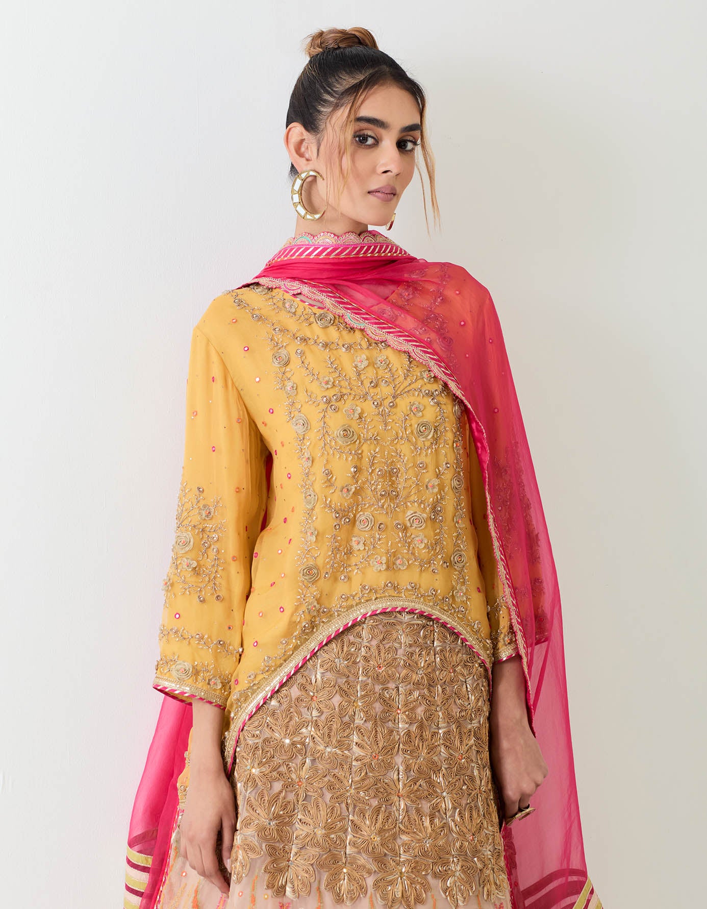 Organza hand embellished high low tunic paired with gota, mirror work and cross stitch embroidered skirt and fuchsia organza dupatta