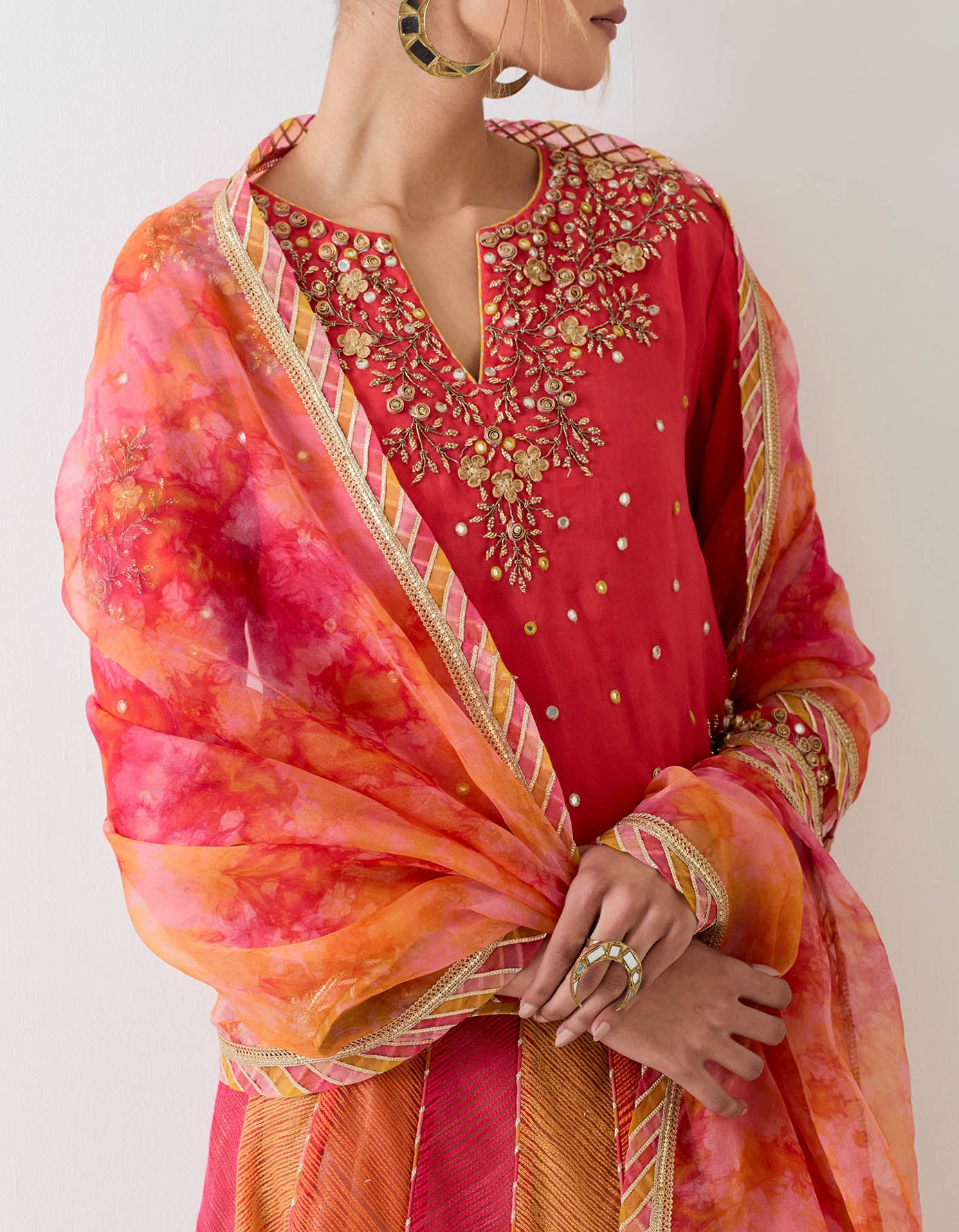 Hand embellished organza kurti paired with textured panelled skirt with hand embroidered waist and organza dupatta