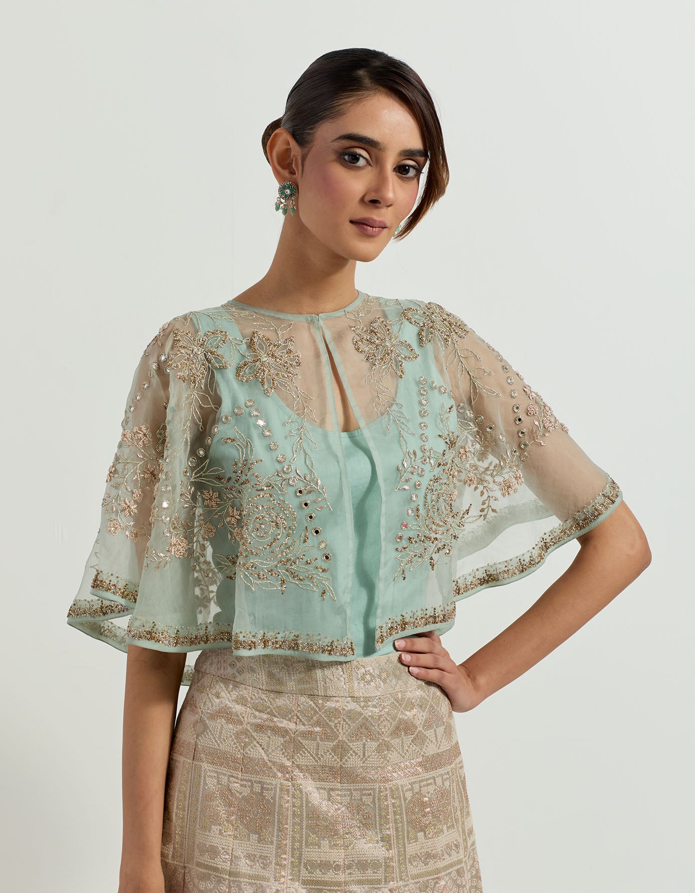 Hand embellished circular organza cape paired with sage tissue skirt in bandhini motifs