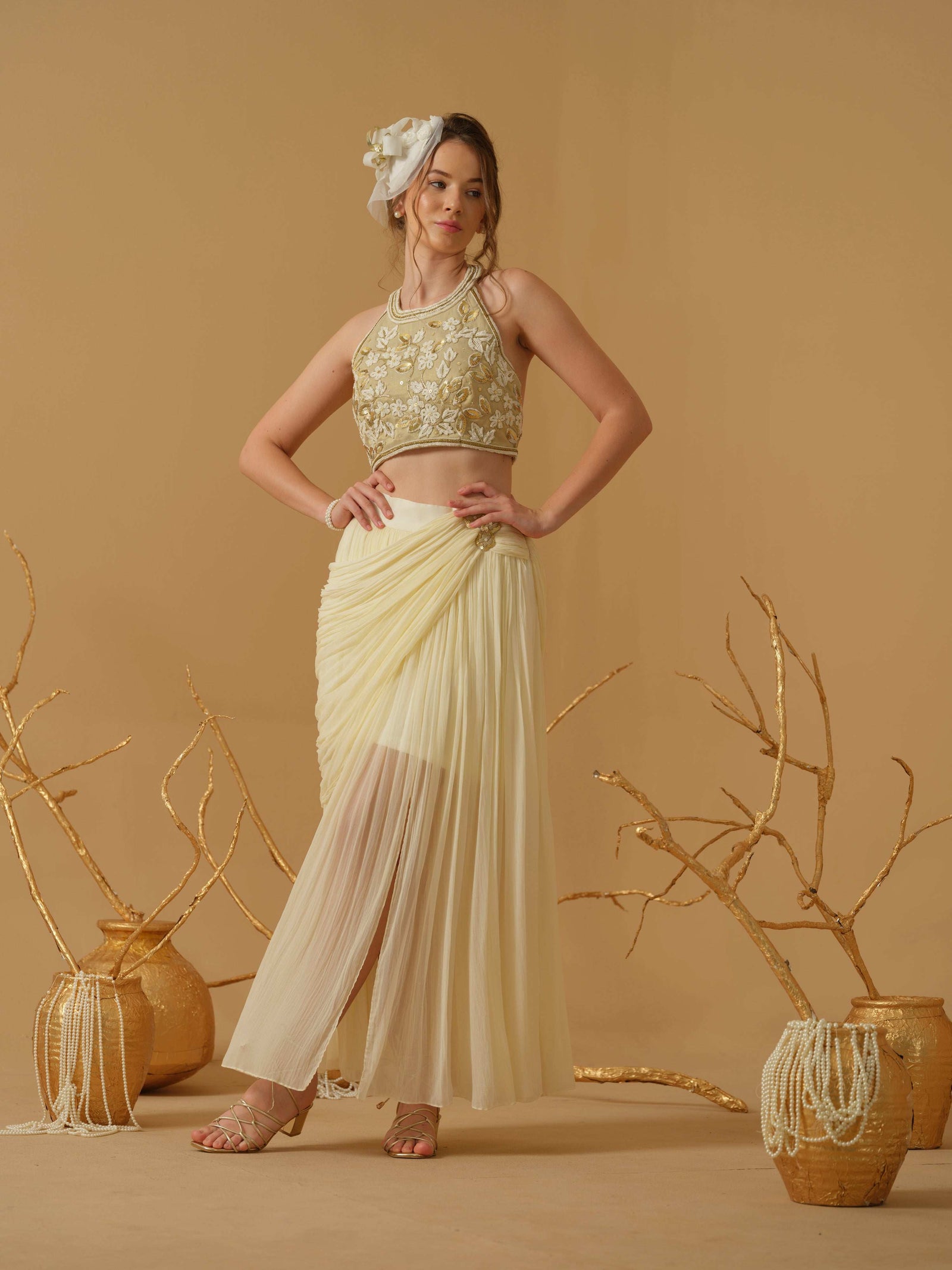 A Halter Neck Blouse Having Floral Embroidery Paired With Draped Skirt