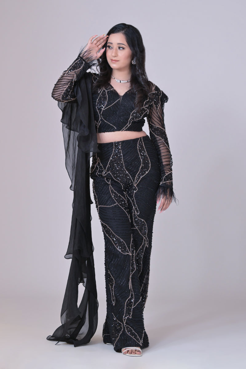 Black crop top with attached organza drape and embelished pants