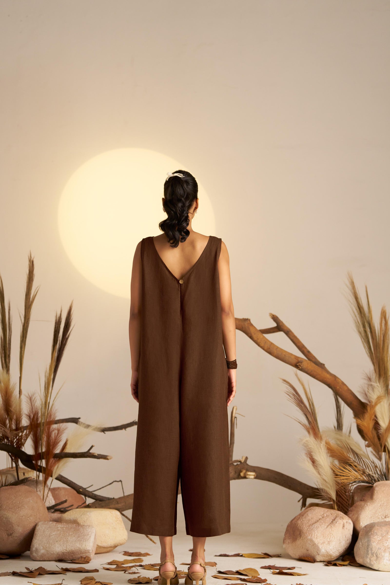 A Sleek Sleeveless Jumpsuit In A Sepia Coloured Hue, Designed With A Flattering Silhouette And Minimalist Detailing