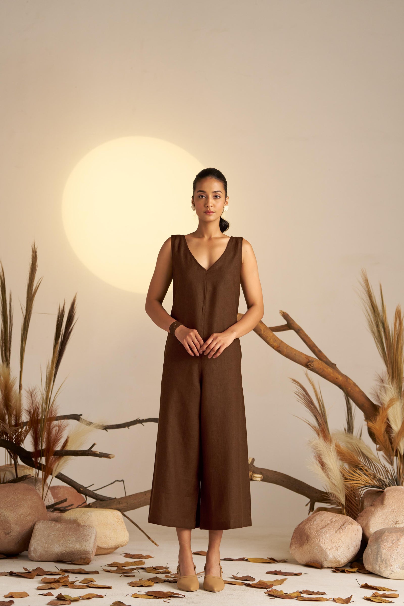 A Sleek Sleeveless Jumpsuit In A Sepia Coloured Hue, Designed With A Flattering Silhouette And Minimalist Detailing