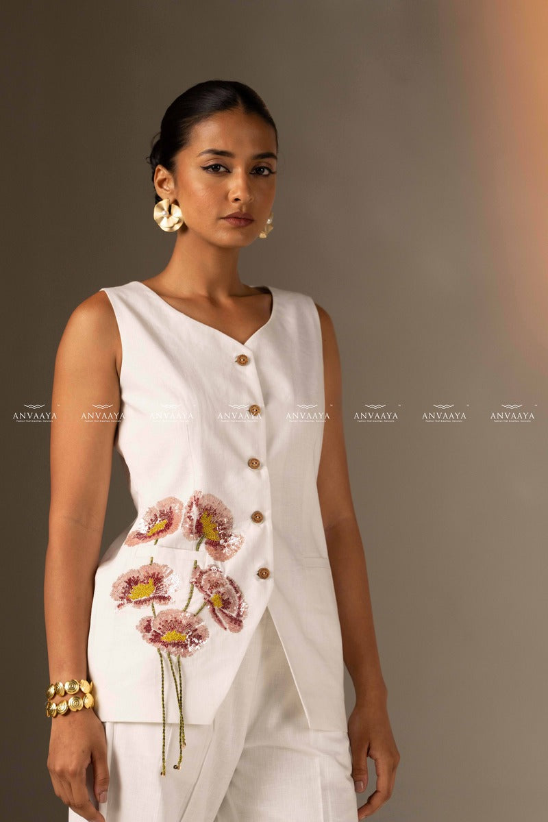 An Elegant White Sleeveless Long Vest Adorned With Delicate Floral Embellishments
