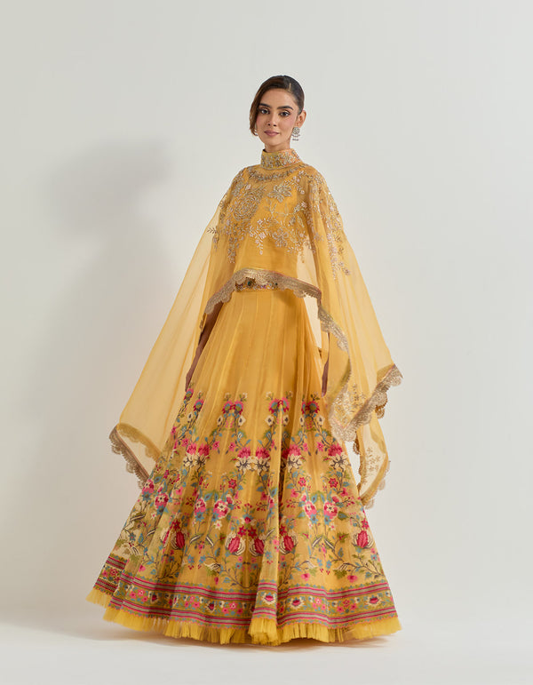 Hand emebllished dupatta cape paired with cross stitch embroidered skirt with frill detail at the hem