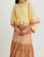 Yellow cross stitch embroidered skirt in landscape motif paired with crinkle georgette poncho top in  gota embroidery