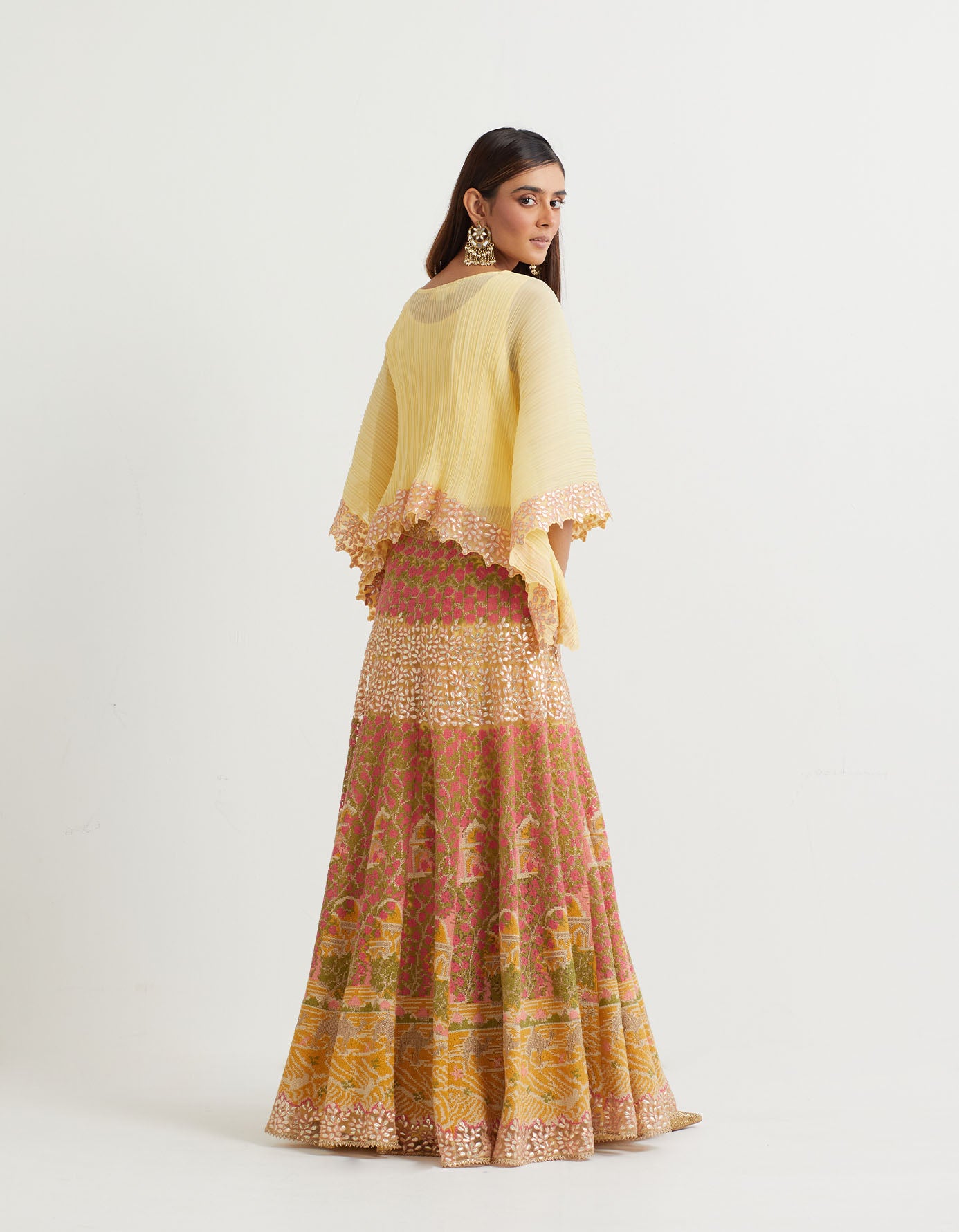 Yellow cross stitch embroidered skirt in landscape motif paired with crinkle georgette poncho top in  gota embroidery