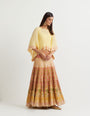 Yellow cross stitch embroidered skirt in landscape motif paired with crinkle georgette poncho top in  gota embroidery