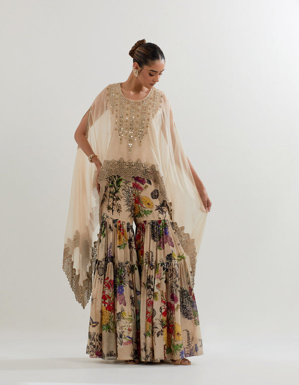 Organza dupatta cape with hand embellished neckline paired with botanical printed pleated sharara