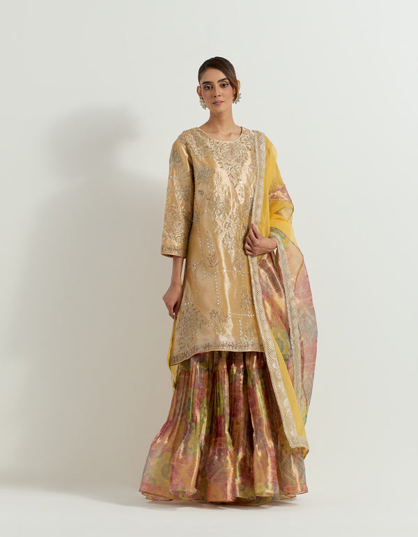 Yellow and gold tissue hand embellished long tunic paired with tissue bandhini printed pleated sharara and organza and tissue patch work dupatta