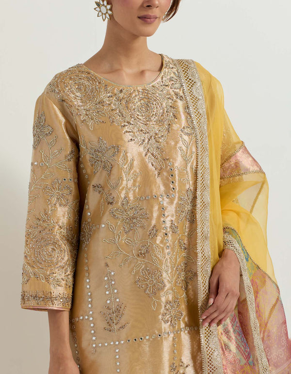 Yellow and gold tissue hand embellished long tunic paired with tissue bandhini printed pleated sharara and organza and tissue patch work dupatta