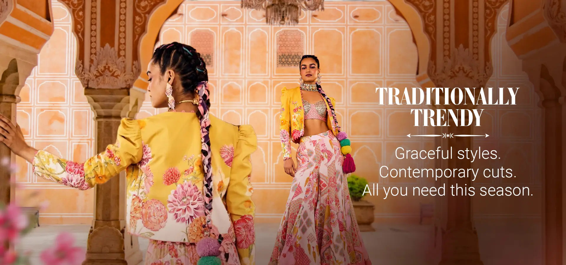 Two women in colorful traditional outfits with a decorative background, featuring the brand 'Traditionally Trendy'.