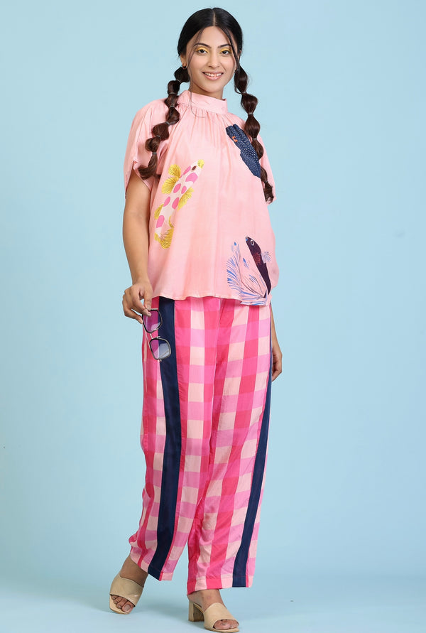 Peach fish print top with dolmain sleeves and a striped straight pant