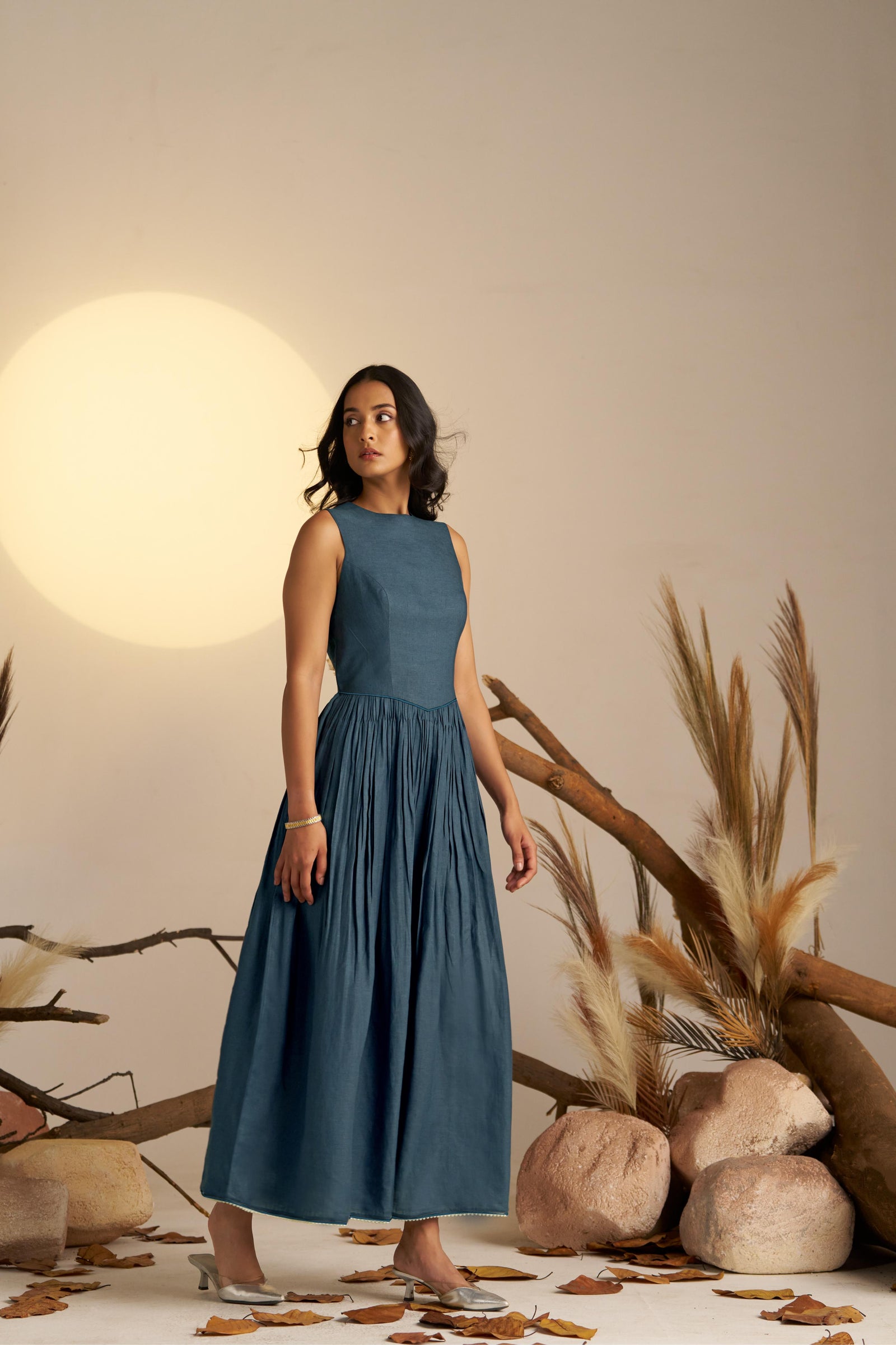 A Stunning Midnight Blue Pleated Dress, Cinched At The Waist To Create A Flattering, Feminine Silhouette